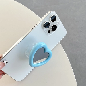 Detail of light blue heart-shaped phone grip with mirror on a white smartphone