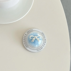 Detail of transparent ball phone grip with white bow and Gift For You text on fur base