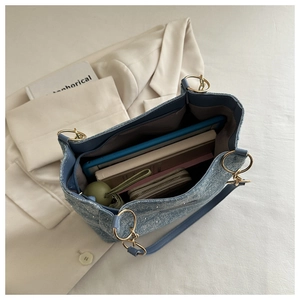 Detail view of large capacity tote bag interior with denim texture and gold ring handle