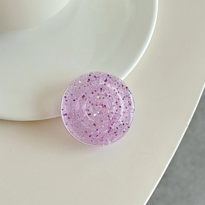 Detail of a purple round phone grip featuring glitter sequins and a translucent design