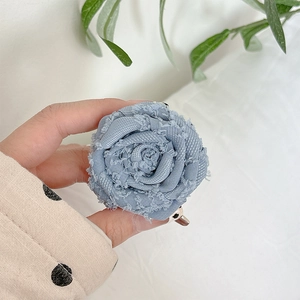 Detailed macro view of a light blue fabric rose phone grip with vintage frayed edges