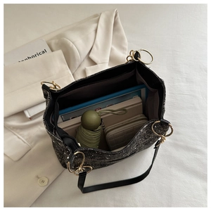 Detail view of large black tweed tote bag interior showing spacious storage capacity