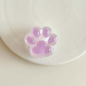 Gros plan du support téléphone patte de chat violette avec texture gelée sur plateau