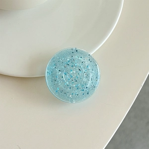Detail of light blue glitter phone socket stand with sparkling sequins and round resin edges