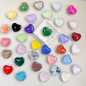 Magnetic retractable heart-shaped glass phone grip stands in various vibrant colors