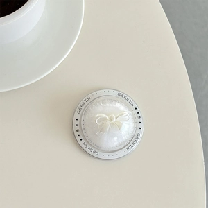 Macro detail of white bow powder puff set in a transparent gift box with text