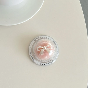Detail view of round transparent phone grip with pink plush and silver bow gift packaging