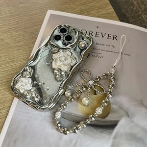 Close-up of silver plating phone case with 3D camellia flowers and pearl bow charm