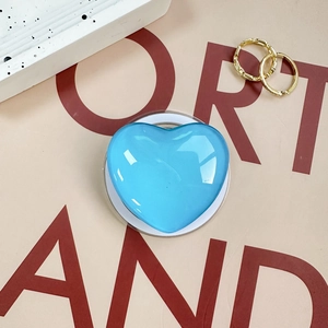 Detail of light blue heart-shaped resin phone grip with polished high-gloss finish