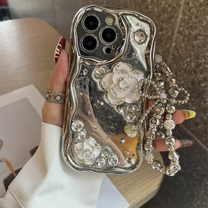 Close-up of silver electroplated wave case with white camellias and beaded chain