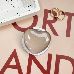 Macro view of champagne gold heart phone grip with reflective mirror finish and clear base