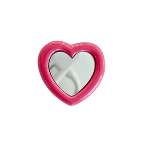 Pink heart-shaped foldable phone socket mirror stand for desktop use on white background