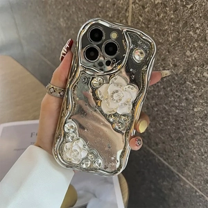 Detail of silver wavy iPhone case featuring white camellia flowers and sparkling rhinestones