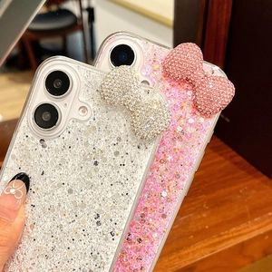 Detailed close-up of 3D rhinestone bow decoration on glitter iPhone cases in silver and pink