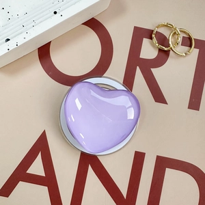 Detail of a purple heart-shaped glass phone stand on a decorative aesthetic background