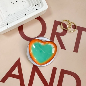 Macro detail of heart-shaped magnetic phone grip with green and orange gradient finish