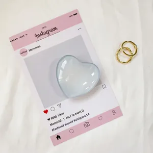Dettaglio del supporto per telefono a forma di cuore in vetro azzurro su card deco