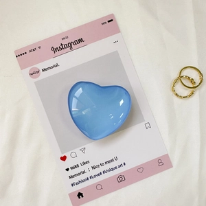 Dettaglio di un supporto per telefono a cuore blu lago lucido su carta decorativa