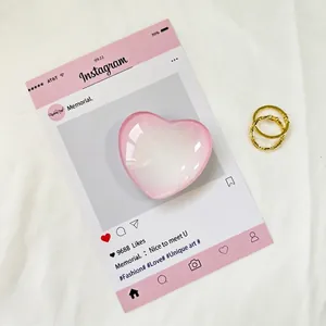 Vista dettagliata del supporto in cristallo rosa a cuore con anelli dorati su tessuto