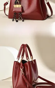 Détail du sac à main en cuir verni bordeaux avec texture brillante et mini porte-monnaie
