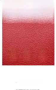 Macro shot of red lychee grain leather texture with soft finish on a classic handbag