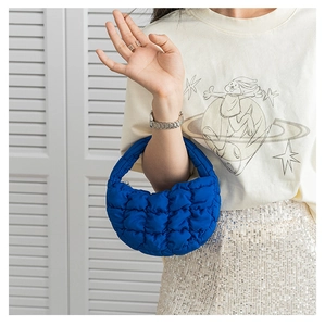 Détail du mini sac à main matelassé bleu vif avec un design texturé de sac nuage