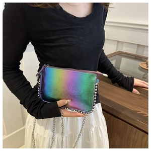Holographic envelope bag with silver bead trim and metallic chain strap worn by a model