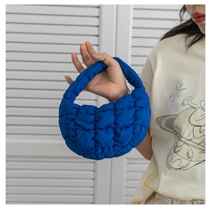 Détail du mini sac matelassé bleu marine avec texture nuage et poignée rembourrée