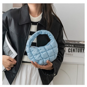 Détail du sac nuage bleu clair matelassé montrant la texture en nylon et l'anse rembourrée