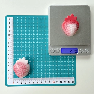 3D strawberry phone grip stand shown on scale weighing 21.8g and measuring 4cm height