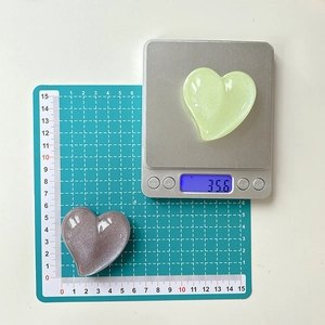 Detailed view of heart-shaped glitter phone grips with size and weight measurement