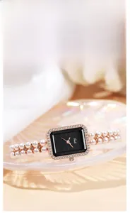 Macro detail of luxury square quartz watch with pearl bead strap and crystal bezel