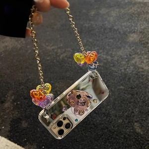 Detail of mirror iPhone case with a purple gemstone and silver heart charm chain