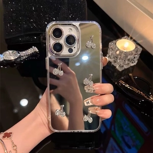 Detail of mirror silver iPhone case with luxury rhinestone cherry charms and metallic edge