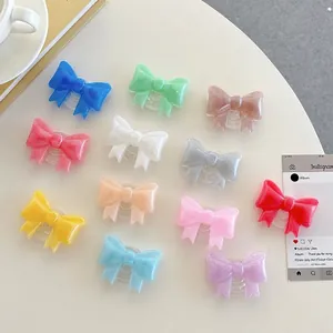 Collapsible bow-knot phone socket stands in various macaron colors on a white table