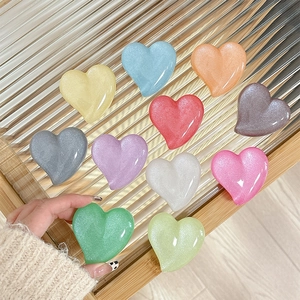 Glitter heart phone socket grips in 11 colors shown on a modern striped glass tray