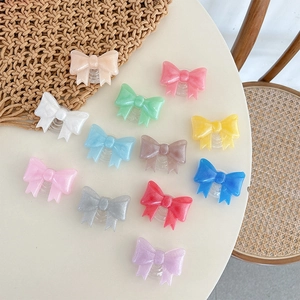 Bow-shaped phone socket grip set in 12 pearlescent colors arranged on a white table