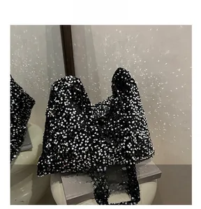 Détails de sequins argentés haute densité sur le tissu noir d'un sac cabas de soirée chic