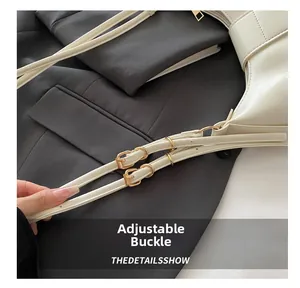 Detail of adjustable double buckle on beige leather shoulder bag with gold hardware