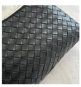 Close-up of premium black woven leather texture and detailed checkerboard craftsmanship