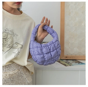 Gros plan d'un sac nuage matelassé lavande avec une texture brillante et un rembourrage