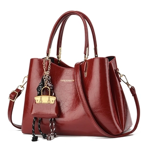 Sac à main en cuir verni bordeaux avec doubles poignées et bandoulière réglable