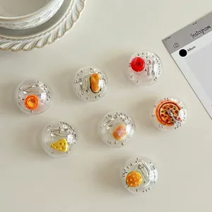 Transparent spherical phone grip with miniature food models like pizza and burger inside