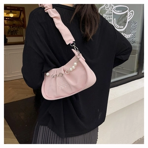 Detail of pink pleated crescent bag with pearl floral chain and heart emblem on the side