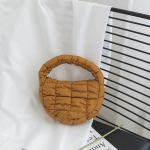 Détail du sac nuage matelassé jaune moutarde avec texture bulle et poignée rembourrée