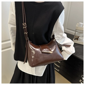 Detailed close-up of vintage dark brown faux leather shoulder bag with glossy finish
