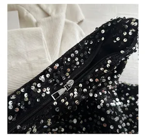 Détail de la fermeture éclair argentée fluide sur le sac cabas à paillettes noires