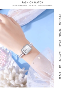 Detail of elegant rectangular quartz watch featuring diamond bezel and white pearl strap