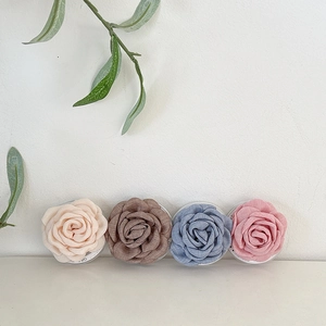 Détail de fleurs de camélia en tissu beige, marron, bleu et rose pour support mobile