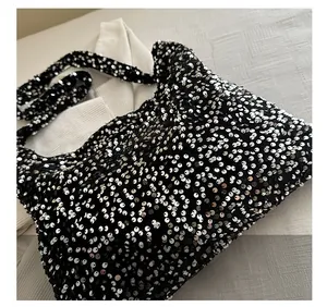 Gros plan des paillettes noires et argentées étincelantes sur le grand sac cabas chic